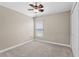 Neutral bedroom features a ceiling fan, closet and a window with natural light and beige carpet at 4153 Cortland Dr, Davenport, FL 33837