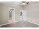 Neutral carpeted bedroom features a ceiling fan and opens to a bathroom and access to the yard at 4153 Cortland Dr, Davenport, FL 33837