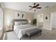 Beautifully staged bedroom with queen bed, neutral tones, art, and ceiling fan; bathroom en suite visible at 4153 Cortland Dr, Davenport, FL 33837