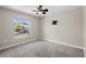 Clean bedroom featuring a ceiling fan, soft carpeting, a window looking out to the neighborhood, and a television mount at 4153 Cortland Dr, Davenport, FL 33837