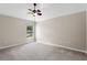 Neutral bedroom features a ceiling fan, a window with natural light and beige carpet at 4153 Cortland Dr, Davenport, FL 33837