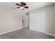 Relaxing bedroom with neutral carpet, a ceiling fan, a double closet, and access to the bathroom and other rooms at 4153 Cortland Dr, Davenport, FL 33837