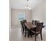 This dining room features a chandelier, a large window with a view and dark wood table and chairs at 4153 Cortland Dr, Davenport, FL 33837