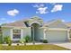 Inviting single-story home boasts a well-manicured lawn, a two-car garage, and attractive architectural detailing at 4153 Cortland Dr, Davenport, FL 33837