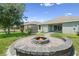 Outdoor brick fire pit with backyard view and hot tub in a fenced yard at 4153 Cortland Dr, Davenport, FL 33837