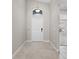 Bright and airy foyer with neutral-toned tile flooring, a front door with transom window, and a modern light fixture at 4153 Cortland Dr, Davenport, FL 33837