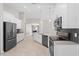 Open kitchen design with white cabinets, gray countertops, dark appliances, and tile flooring at 4153 Cortland Dr, Davenport, FL 33837