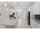 Bright kitchen features white cabinetry, stainless appliances, large sink, and tile floors at 4153 Cortland Dr, Davenport, FL 33837