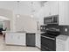 Modern kitchen boasts white cabinets, dark appliances, gray countertops, backsplash, and tile floors at 4153 Cortland Dr, Davenport, FL 33837