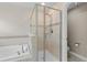 Modern bathroom with tiled shower, glass door, adjacent tub, and toilet area, creating a spa-like retreat at 4153 Cortland Dr, Davenport, FL 33837
