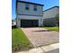 Spacious brick driveway leading to a two-car garage with a well-manicured lawn at 4716 Homestead Trl, St Cloud, FL 34772