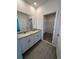 Bathroom featuring double sink vanity with granite countertops and a walk-in closet at 4716 Homestead Trl, St Cloud, FL 34772