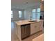 Kitchen island with stainless steel dishwasher overlooking a bright living space at 4720 Homestead Trl, St Cloud, FL 34772