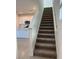 Carpeted staircase leading to the upper level, with an adjacent modern kitchen at 4720 Homestead Trl, St Cloud, FL 34772