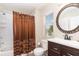 Bathroom featuring a tub with shower, a dark vanity, and a decorative mirror at 5037 Hawkstone Dr, Sanford, FL 32771