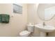A powder room with pedestal sink, round mirror and a window for natural light at 5037 Hawkstone Dr, Sanford, FL 32771