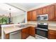 Well-equipped kitchen with stainless steel appliances, stainless sink, and a serving hatch looking to the dining area at 5037 Hawkstone Dr, Sanford, FL 32771