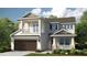 Charming two-story home featuring a covered front porch, balcony, and a two-car garage nestled among mature trees at 5223 Quillback Ln, St Cloud, FL 34771