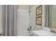 Well-lit bathroom with white tile, bathtub, shower, and stylish fixtures at 5259 Quillback Ln, St Cloud, FL 34771