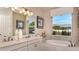 Bright bathroom featuring double sinks, soaking tub, and neutral color scheme at 5259 Quillback Ln, St Cloud, FL 34771