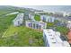 An aerial view shows the condo buildings and nearby scenery featuring the beach, trees, and waterways at 5300 S Atlantic Ave # 6-301, New Smyrna Beach, FL 32169
