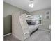 This cozy bedroom features a bunk bed with built in stairs and a window with shutters at 5300 S Atlantic Ave # 6-301, New Smyrna Beach, FL 32169
