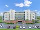 The exterior of this condo features a parking lot, balconies, and landscaping with tropical trees and bushes at 5300 S Atlantic Ave # 6-301, New Smyrna Beach, FL 32169