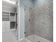 Modern bathroom showcasing a glass-enclosed shower with tiled walls and a walk-in closet at 5711 Hamlin Groves Trl, Winter Garden, FL 34787