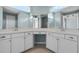 Elegant bathroom featuring a dual sink vanity with white cabinets and stylish mirrors at 5711 Hamlin Groves Trl, Winter Garden, FL 34787