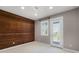 This bedroom features a wood accent wall, neutral carpet, and a door to a private balcony with a view at 5711 Hamlin Groves Trl, Winter Garden, FL 34787