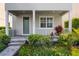 Charming front porch with gray pavers and lush, tropical landscaping at 5711 Hamlin Groves Trl, Winter Garden, FL 34787