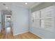 Bright hallway featuring hardwood floors, white trim, and a window with plantation shutters for a warm, inviting space at 5711 Hamlin Groves Trl, Winter Garden, FL 34787