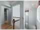 Hallway with wooden floors leads to an open bathroom and lower level, offering a bright and airy transition at 5711 Hamlin Groves Trl, Winter Garden, FL 34787