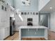 Bright kitchen features a kitchen island, stainless steel appliances, white cabinetry and hardwood floors at 5711 Hamlin Groves Trl, Winter Garden, FL 34787