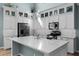 Close up of the kitchen with a quartz countertop island, stainless steel appliances and glass front cabinetry at 5711 Hamlin Groves Trl, Winter Garden, FL 34787
