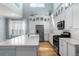 Bright kitchen features a kitchen island, stainless steel appliances, white cabinetry and hardwood floors at 5711 Hamlin Groves Trl, Winter Garden, FL 34787
