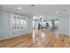 Bright living room with hardwood floors, large windows, and an open floor plan leading to the modern kitchen at 5711 Hamlin Groves Trl, Winter Garden, FL 34787