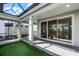 Covered patio featuring brick pavers, outdoor putting green, and access to the living area via sliding glass doors at 5711 Hamlin Groves Trl, Winter Garden, FL 34787