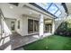 Screened-in patio with brick pavers and outdoor putting green with access to living area via sliding doors at 5711 Hamlin Groves Trl, Winter Garden, FL 34787