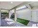 Covered patio featuring brick pavers, outdoor putting green, and door to the backyard at 5711 Hamlin Groves Trl, Winter Garden, FL 34787
