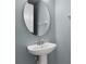 Cozy powder room with pedestal sink and oval mirror at 5711 Hamlin Groves Trl, Winter Garden, FL 34787