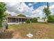 View of the backyard and screened in porch featuring green grass, trees and a chain link fence at 6366 Sw 115Th Street Rd, Ocala, FL 34476