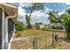 A view of the backyard with a chain-link fence, mature trees, and neighboring homes at 6366 Sw 115Th Street Rd, Ocala, FL 34476