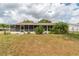 The backyard shows a home with a screened-in porch, lush greenery, and a chain-link fence at 6366 Sw 115Th Street Rd, Ocala, FL 34476