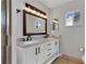 Bathroom featuring double sinks, framed mirror, and a shower at 6366 Sw 115Th Street Rd, Ocala, FL 34476
