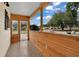 Inviting front porch featuring wood paneling, tiled floor, and bright, natural light at 6366 Sw 115Th Street Rd, Ocala, FL 34476