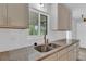 Bright kitchen featuring granite countertops, stainless steel sink, and a view to the lanai at 6366 Sw 115Th Street Rd, Ocala, FL 34476