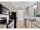 Modern kitchen featuring stainless steel appliances, stylish countertops, and view into living space at 6366 Sw 115Th Street Rd, Ocala, FL 34476