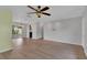 Spacious living room with hardwood floors, ceiling fan, chandelier, and view into other rooms at 6366 Sw 115Th Street Rd, Ocala, FL 34476