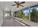 Bright sunroom with large windows showcasing lush outdoor views and ceiling fans at 6366 Sw 115Th Street Rd, Ocala, FL 34476